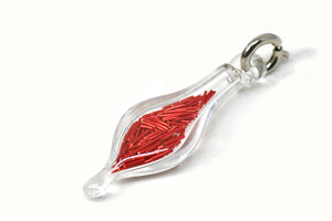 small blown glass charm with cut up red wire inside