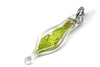 small blown glass charm with cut up lime green wire inside