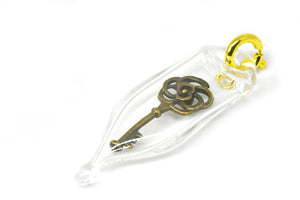 Glass capsule charm with antique brass key inside glass