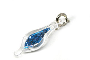 small blown glass charm with cut up blue wire inside
